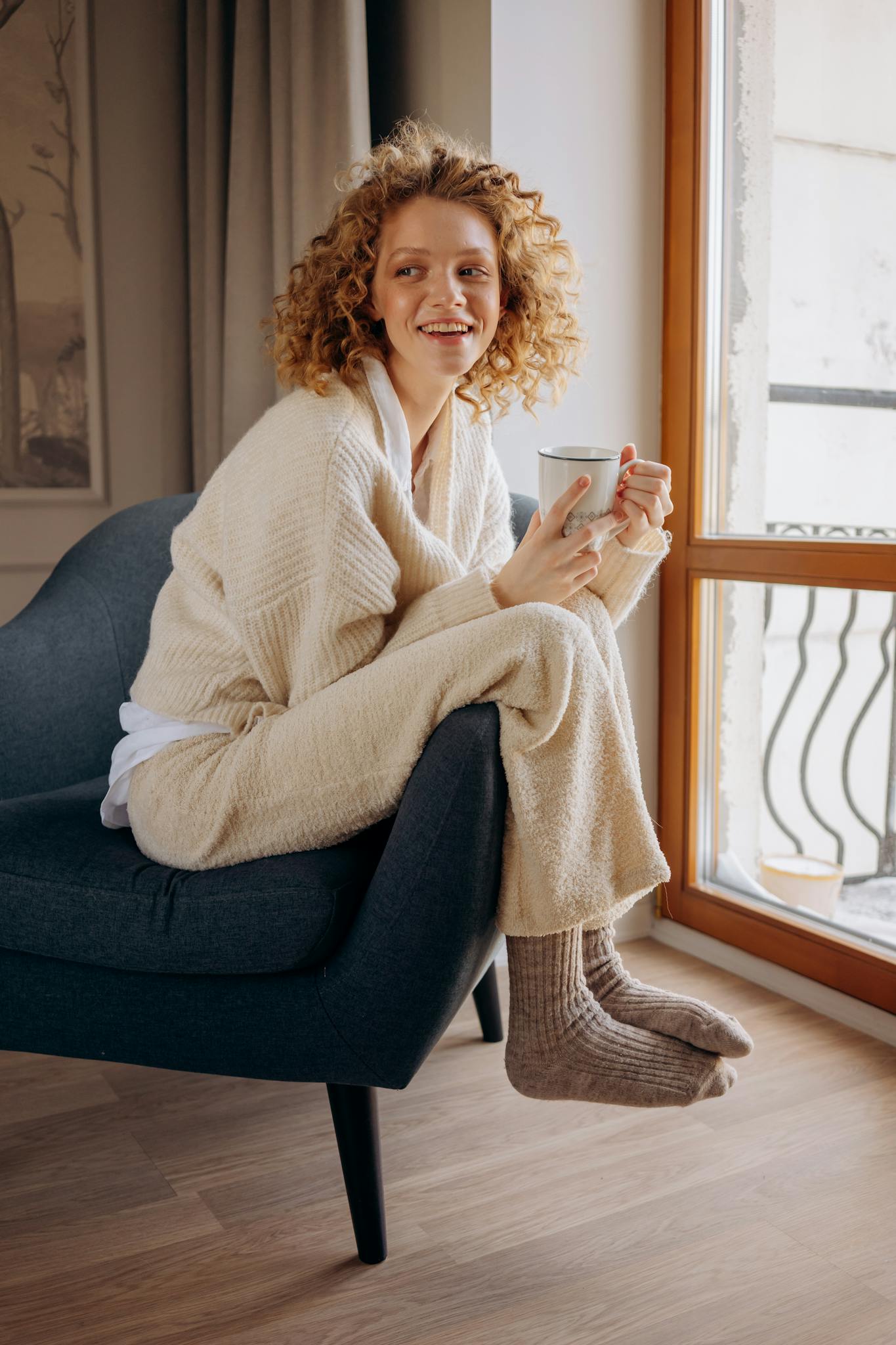 woman sitting comfortably in an armchair holding